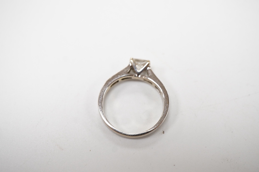 A diamond ring, set with a princess-cut diamond weighing approximately 0.40 carats, to shoulders channel-set with smaller princess-cut diamonds totalling approximately 0.40 carats, mounted in 18ct white gold, size K1/2,